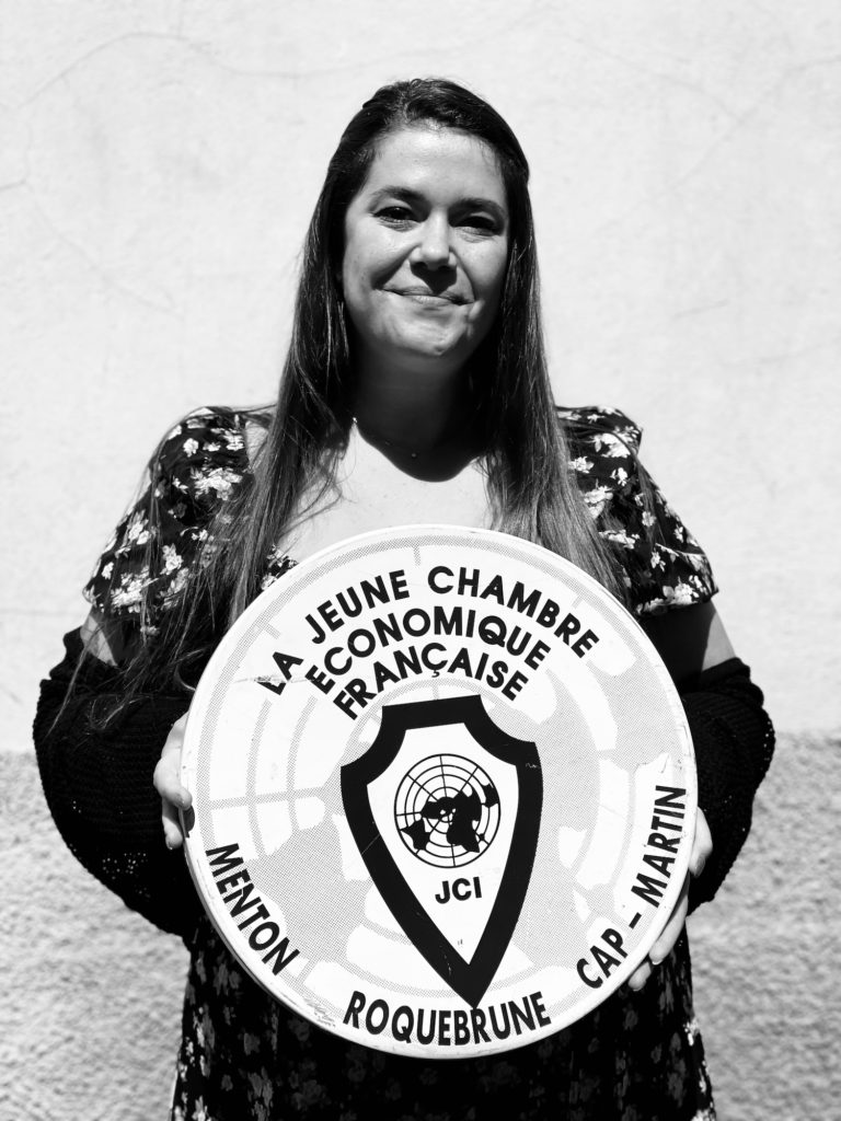 Portrait de Celine LETANG-JOUBERT tenant un panneau de la JCE Menton - RCM